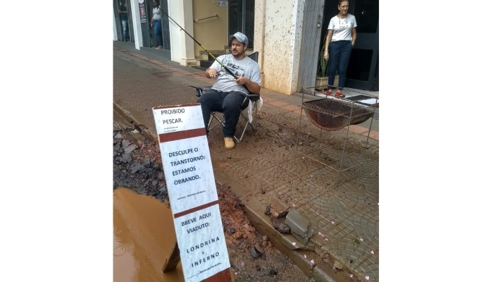 Em protesto, comerciante 'pesca' em buraco de rua no centro de Londrina